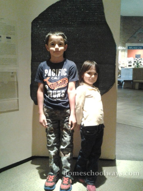 Boy and girl in front of a Rosetta Stone replica