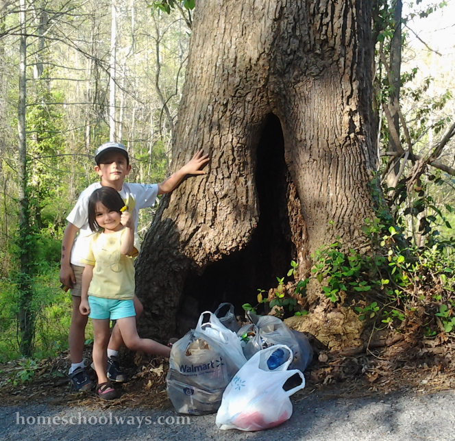 Boy and girl with 13 gallons of trash they picked up for Earth Day