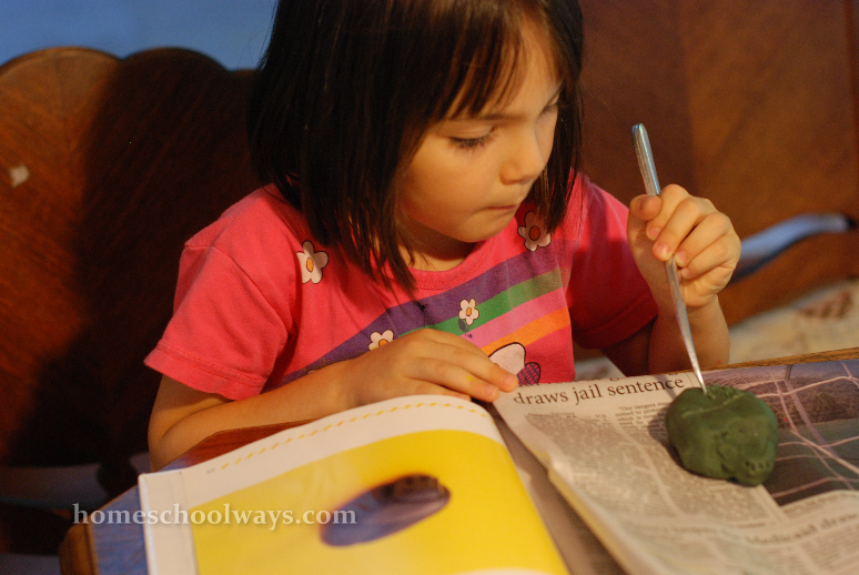 Little girl carving a scarab amulet