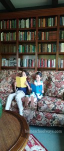 Boy and girl reading on a couch in a private library