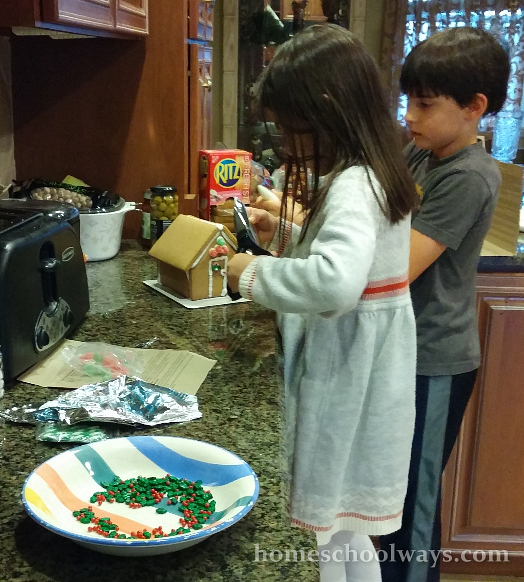Boy and girl decorating a gingerbread house