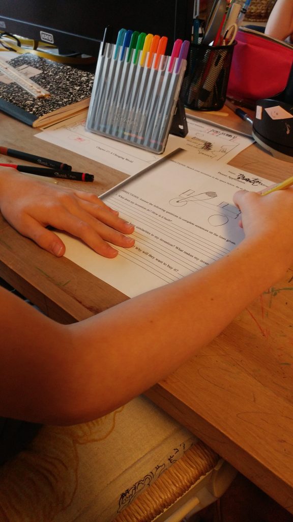 Boy draws invention on paper