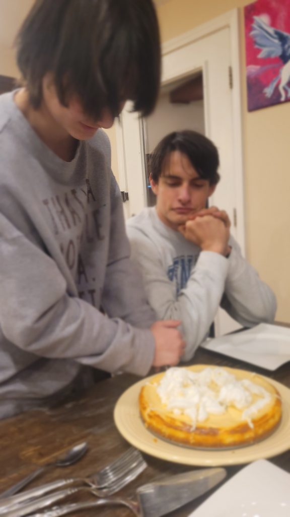 Teenagers cutting a cheesecake